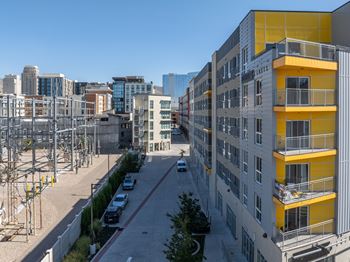 A street view of a city with a yellow building on the right.